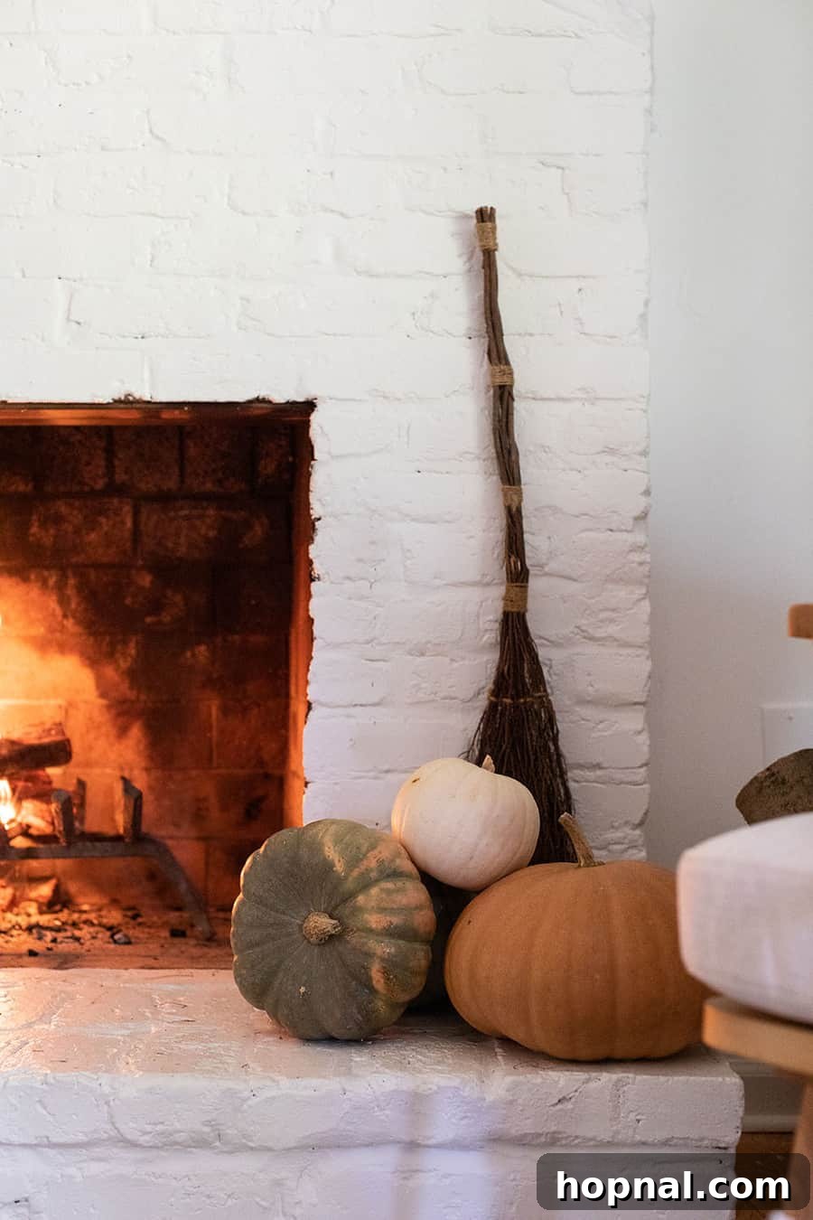 Pumpkins, broomsticks and a fireplace decorated for Halloween
