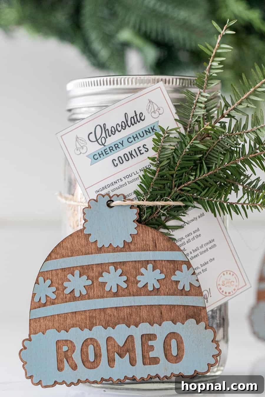 A beautifully prepared chocolate cherry chunk cookie mix in a jar, decorated and ready to be presented as a thoughtful holiday gift.
