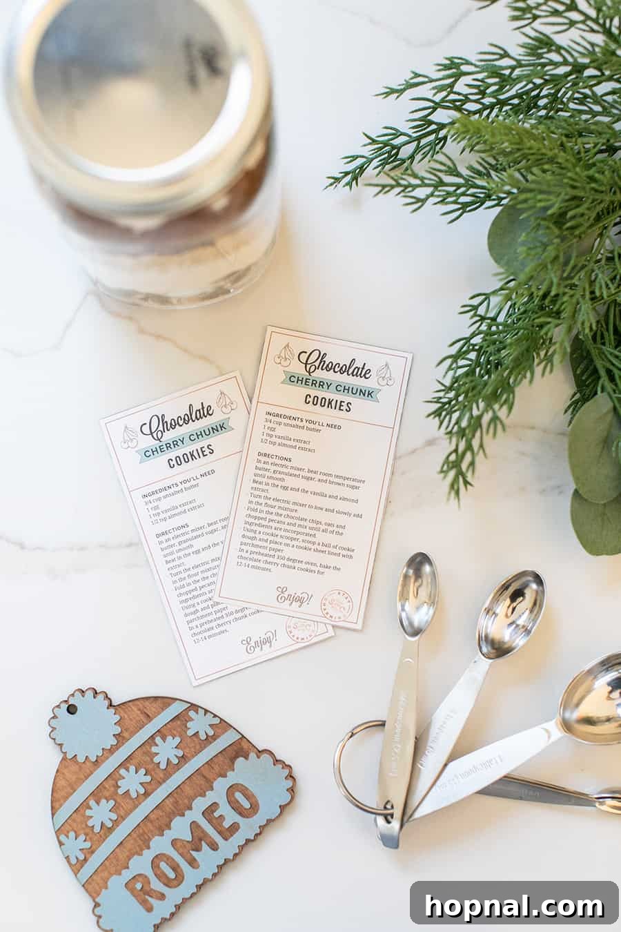 Two festive cookie mix jars, each decorated with a personalized tag, ready to be given as thoughtful holiday gifts.
