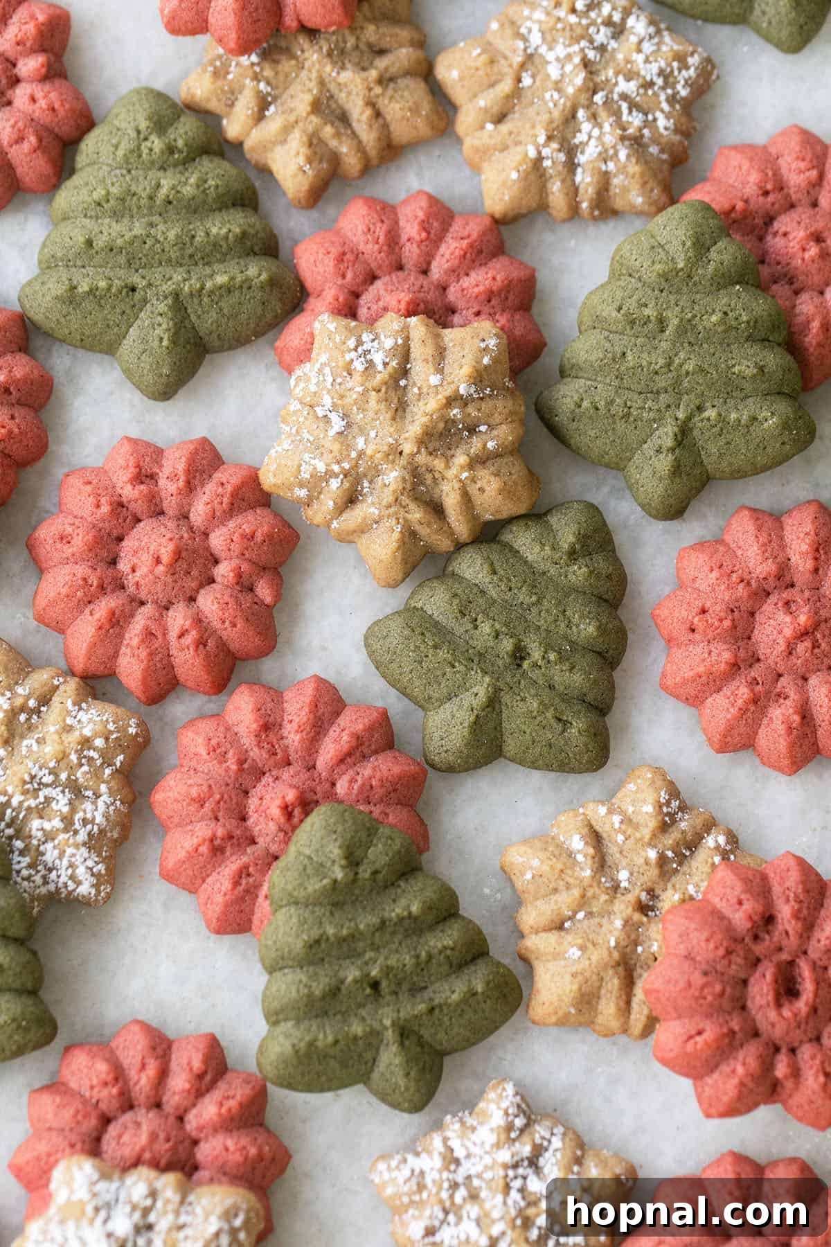 Holiday spritz cookies shaped like stars and trees with gingerbread spice