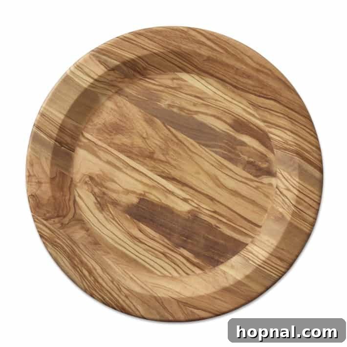 Sparkling Christmas Tablescapes 17 An elegant Olive Wood Charger from Williams Sonoma, a key element in festive Christmas table decorations.
