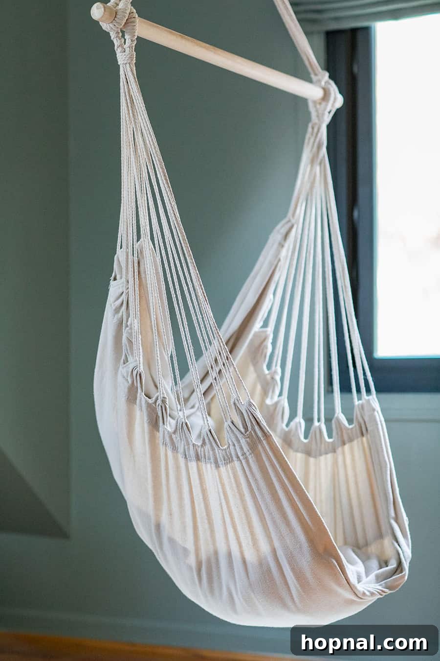 The stylish hammock in a kids bedroom offers a playful and relaxing spot, perfect for a nature-inspired cabin interior.