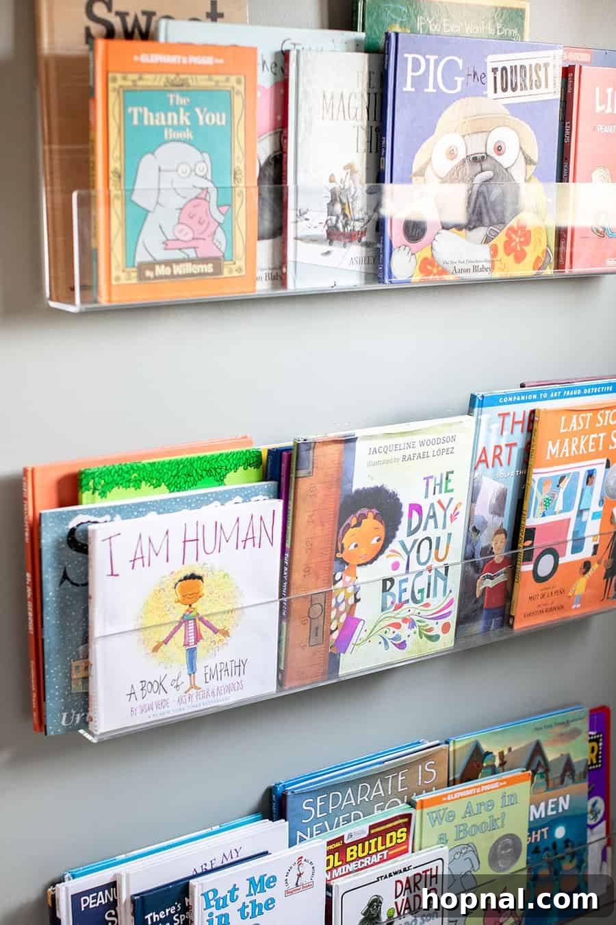 A modern acrylic book shelf provides stylish and practical storage for books in a nature-inspired kids bedroom.