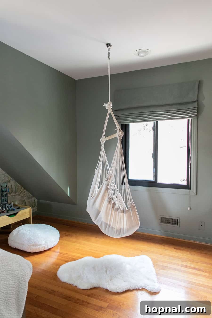 A playful hanging chair from Amazon adds a whimsical touch to a woodsy-themed kids bedroom, perfect for reading and relaxation in a cabin setting.