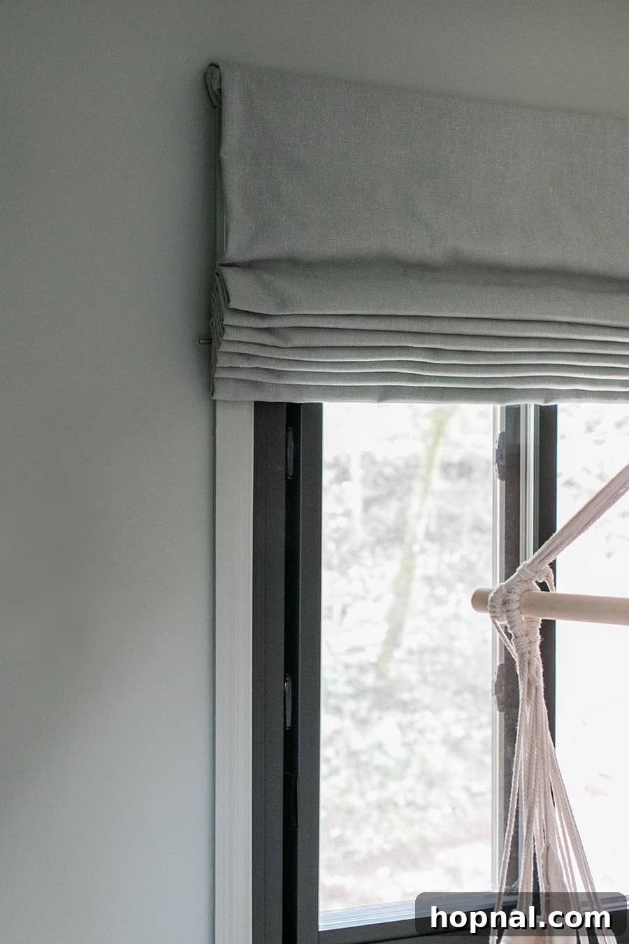 Elegant flat Roman shades from Calico Corners in a kids' bedroom, perfectly matching the wall color for a cohesive and serene woodsy theme.