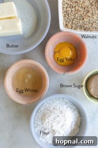 Individual bowls containing prepared ingredients: separated egg yolks and whites, flour, dark brown sugar, and butter, ready for making thumbprint cookies.