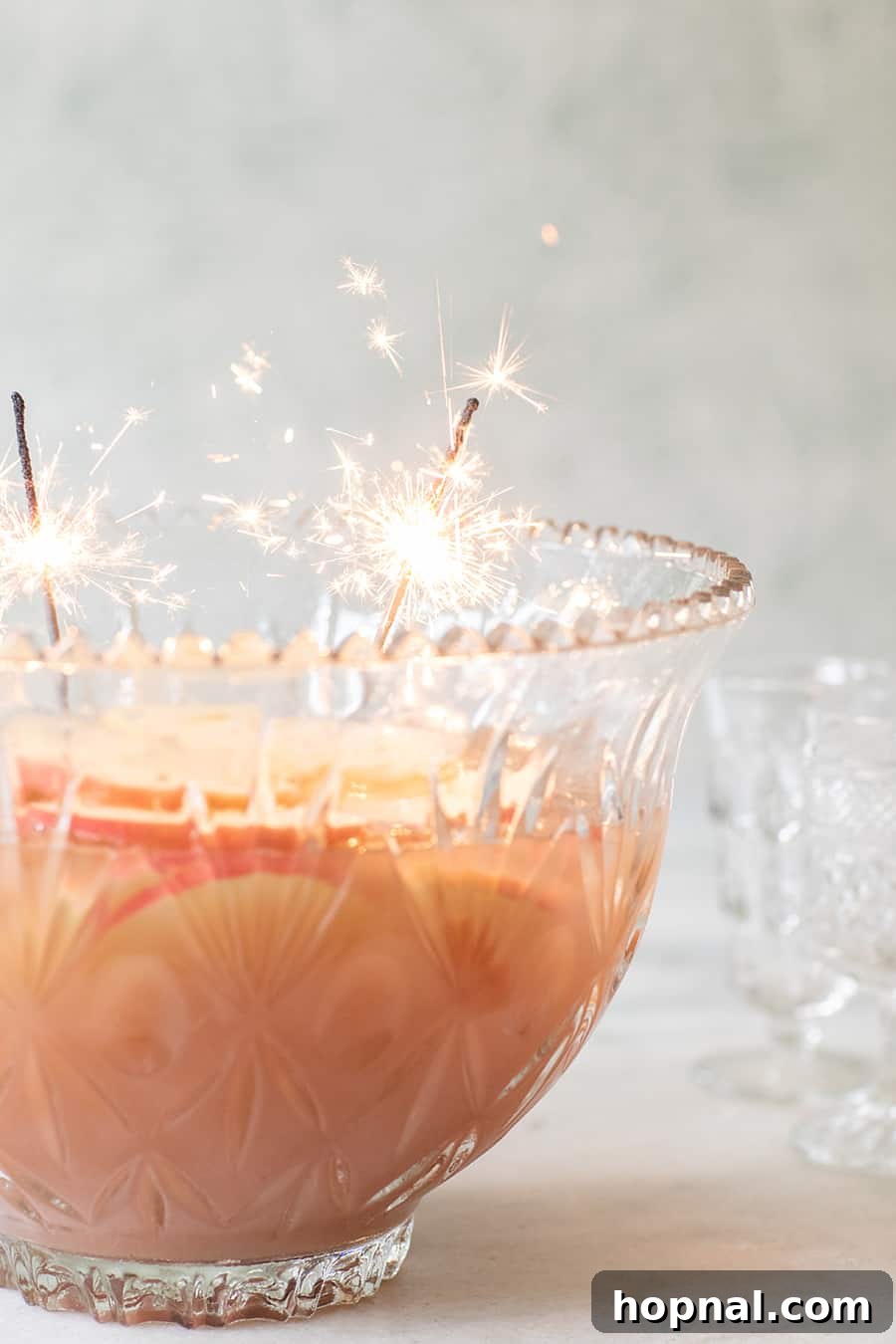 Sparkling Spiced Apple Sparkler Punch for Christmas, garnished with apple slices and cinnamon.