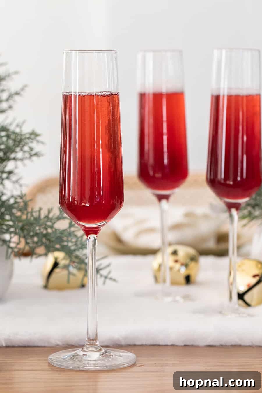 Christmas mimosa made with cranberry juice and Champagne in a flute glass.