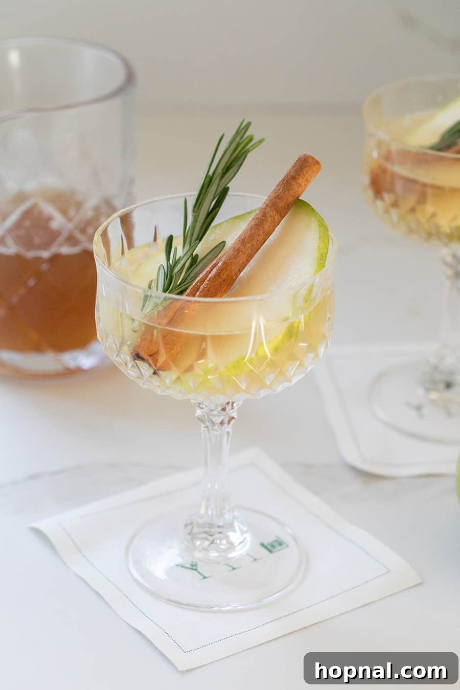 Elegant Partridge in a Pear Tree Christmas cocktail garnished with a pear slice.