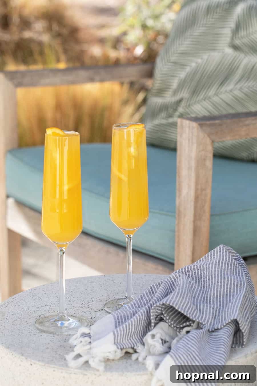 An orange cocktail served outdoors, embodying a refreshing mimosa experience.