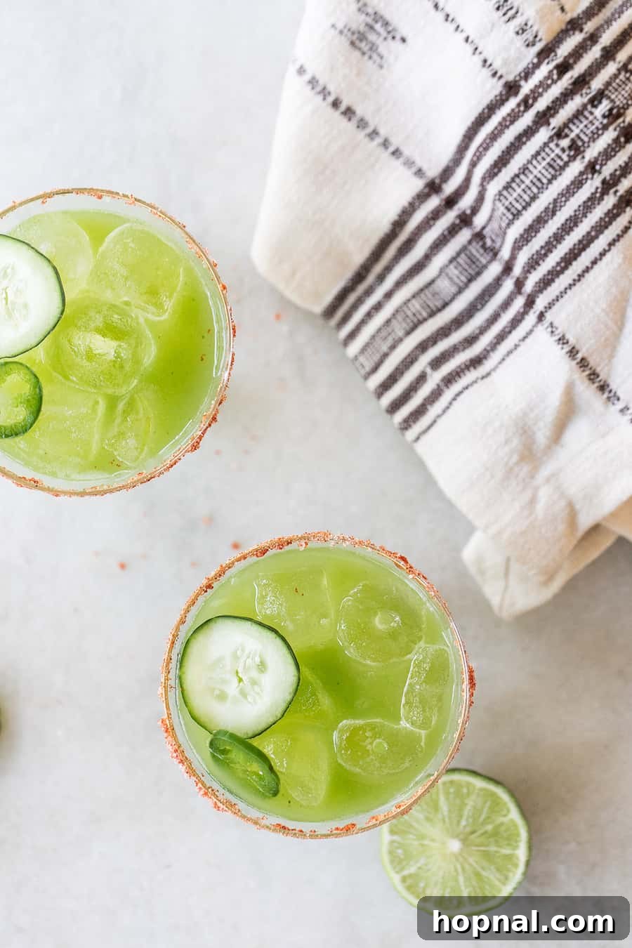 Spicy Tequila Cocktail, the Sergeant Pepper, with cucumber slices and jalapeño garnish in a tall glass.