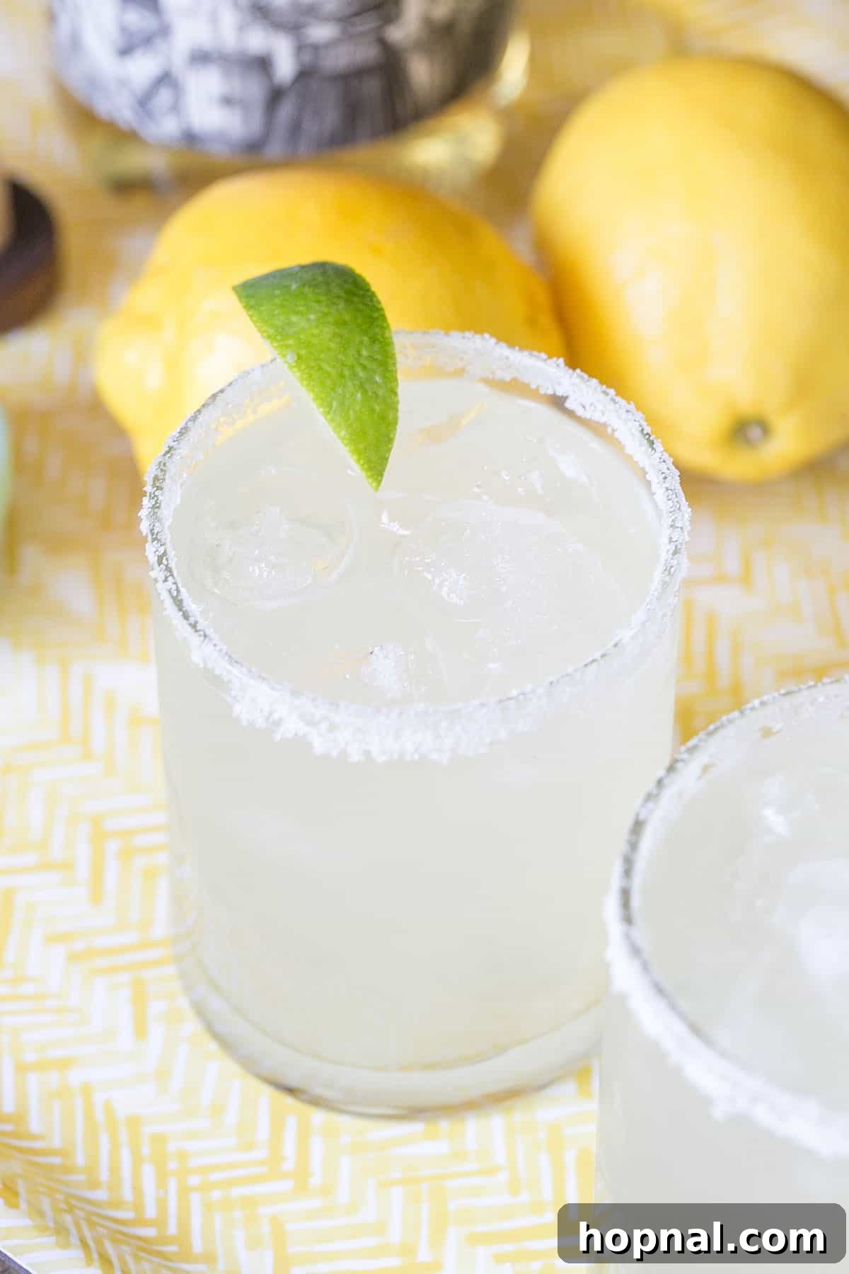 Lemonade Margarita in a tall glass with lemon slices and a sugared rim.
