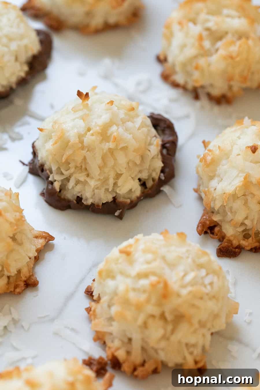Your Ultimate Easter Recipe Collection 15 Perfectly baked coconut macaroons, some dipped in chocolate, a sweet Easter treat.