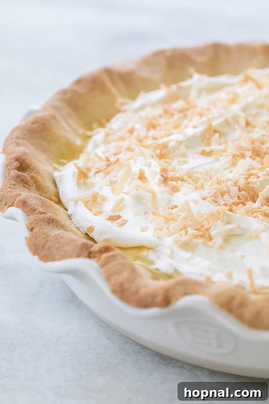 Your Ultimate Easter Recipe Collection 21 Rich coconut cream pie topped with whipped cream and toasted coconut, a perfect Easter indulgence.