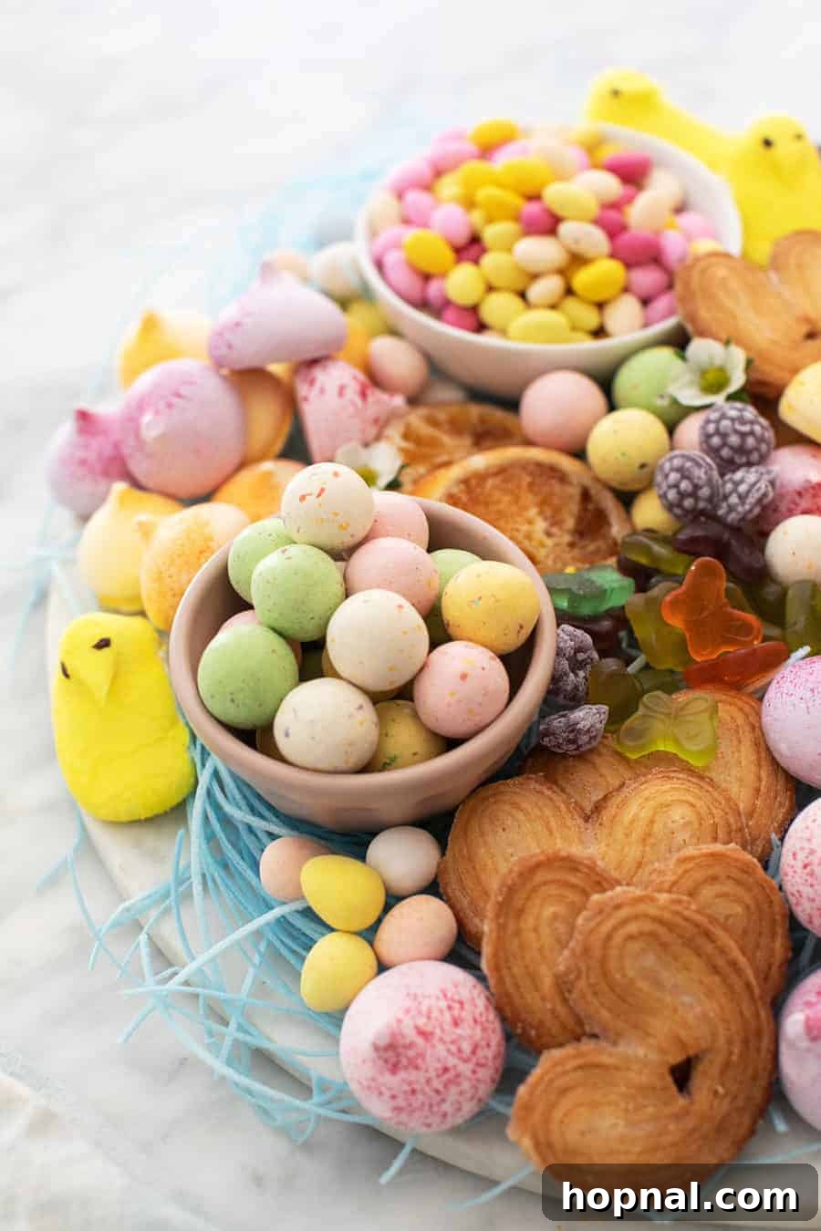 An abundant and colorful Easter dessert candy platter, artfully arranged with various holiday treats and sweets.
