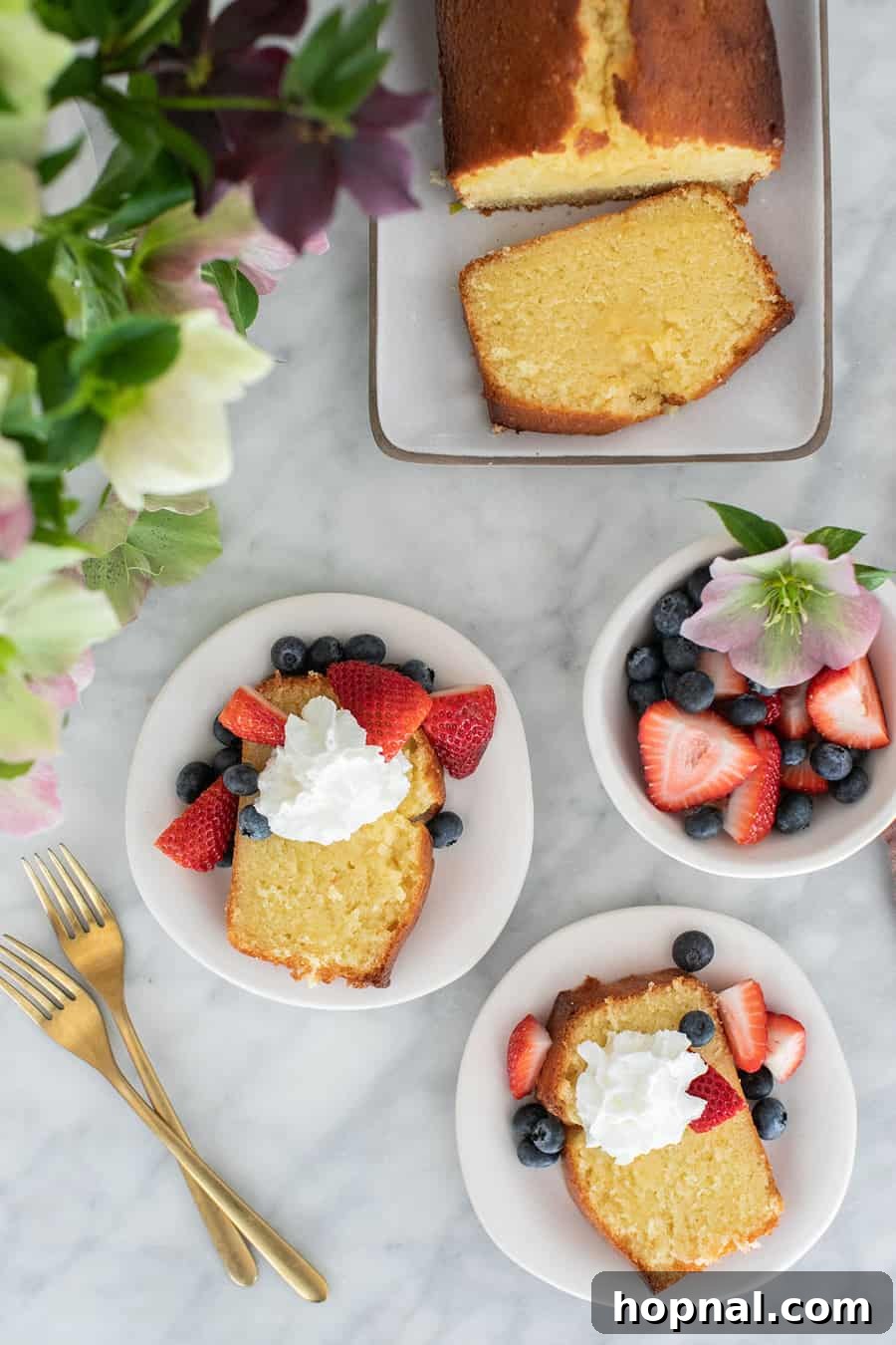 Timeless Pound Cake Perfection 2 A beautifully baked slice of old-fashioned pound cake, served with fresh berries and whipped cream on a delicate white plate, showcasing its golden crust and moist interior.