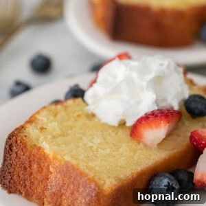 Timeless Pound Cake Perfection 11 Slice of old-fashioned pound cake with whipped cream and berries.
