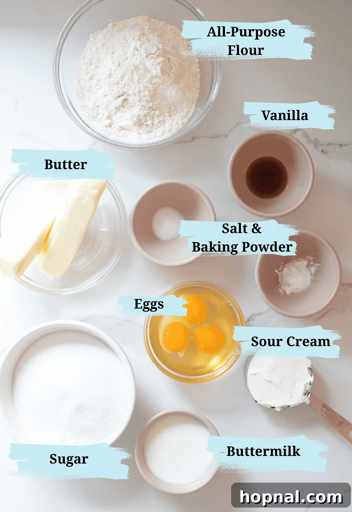 Timeless Pound Cake Perfection 3 A rustic wooden table displaying all the fresh, high-quality ingredients needed for an old-fashioned pound cake recipe: butter sticks, eggs, granulated sugar, a bowl of flour, sour cream, and milk.