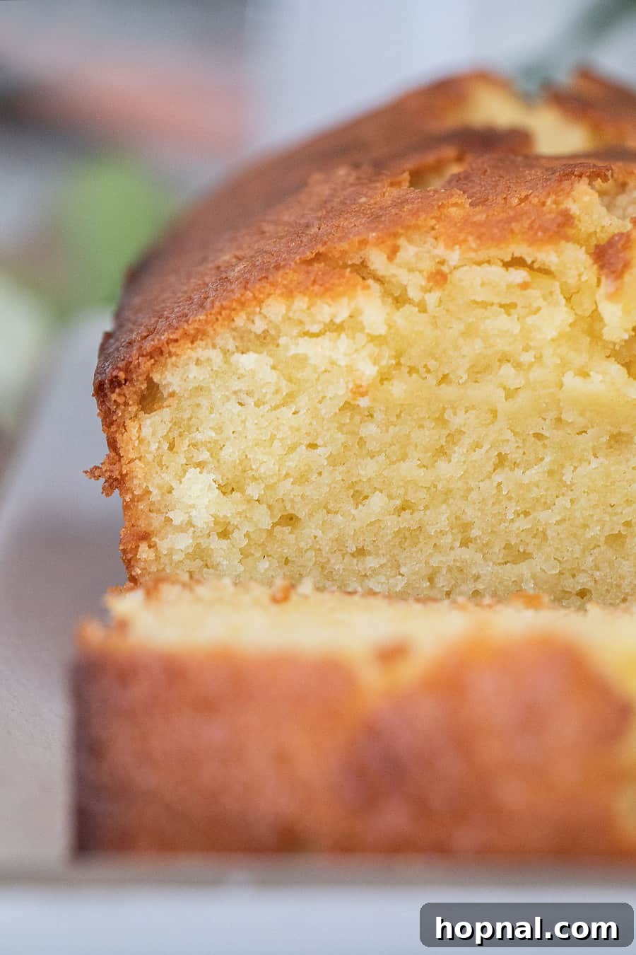 Timeless Pound Cake Perfection 9 A close-up view of a perfectly sliced old-fashioned pound cake, revealing its moist, dense, and buttery texture with a golden crust.