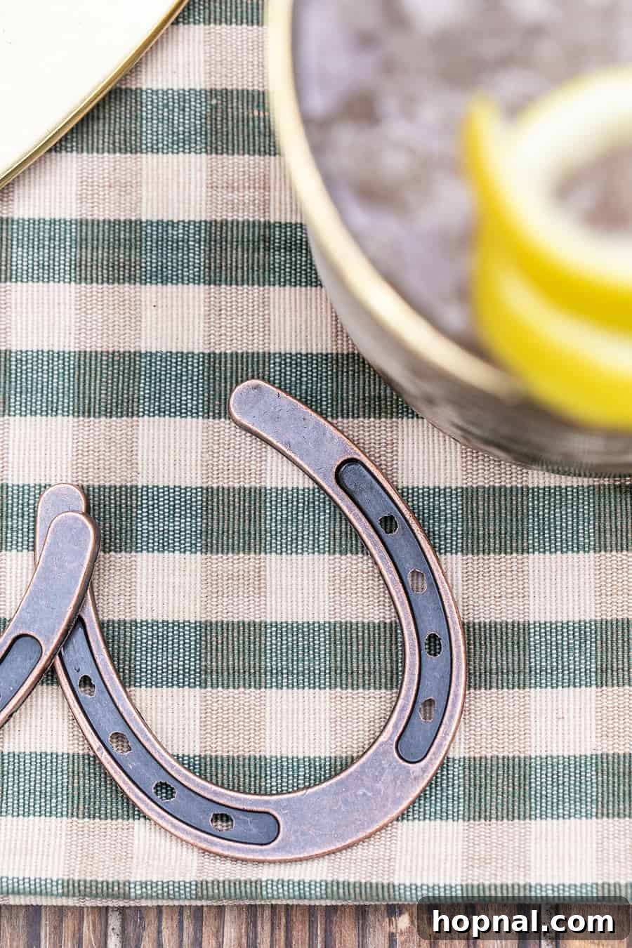 A mini horse shoe resting on a checkered tablecloth, adding a lucky touch to Kentucky Derby decor.
