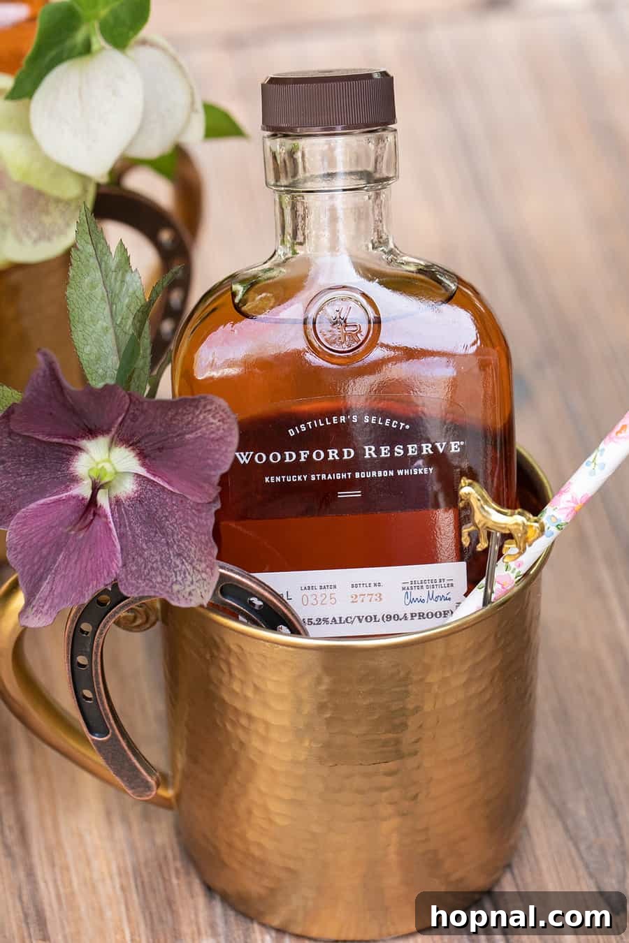 Woodford Reserve miniature bottle, horse pick, and straw in a gold mug as a Kentucky Derby party favor.