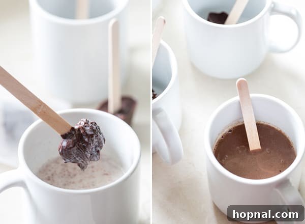 Hot chocolate on a stick being dipped into a mug of hot milk, creating a swirling chocolate effect.