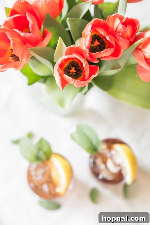 shot of flowers with cocktails next to it, set in a beautiful outdoor or party setting