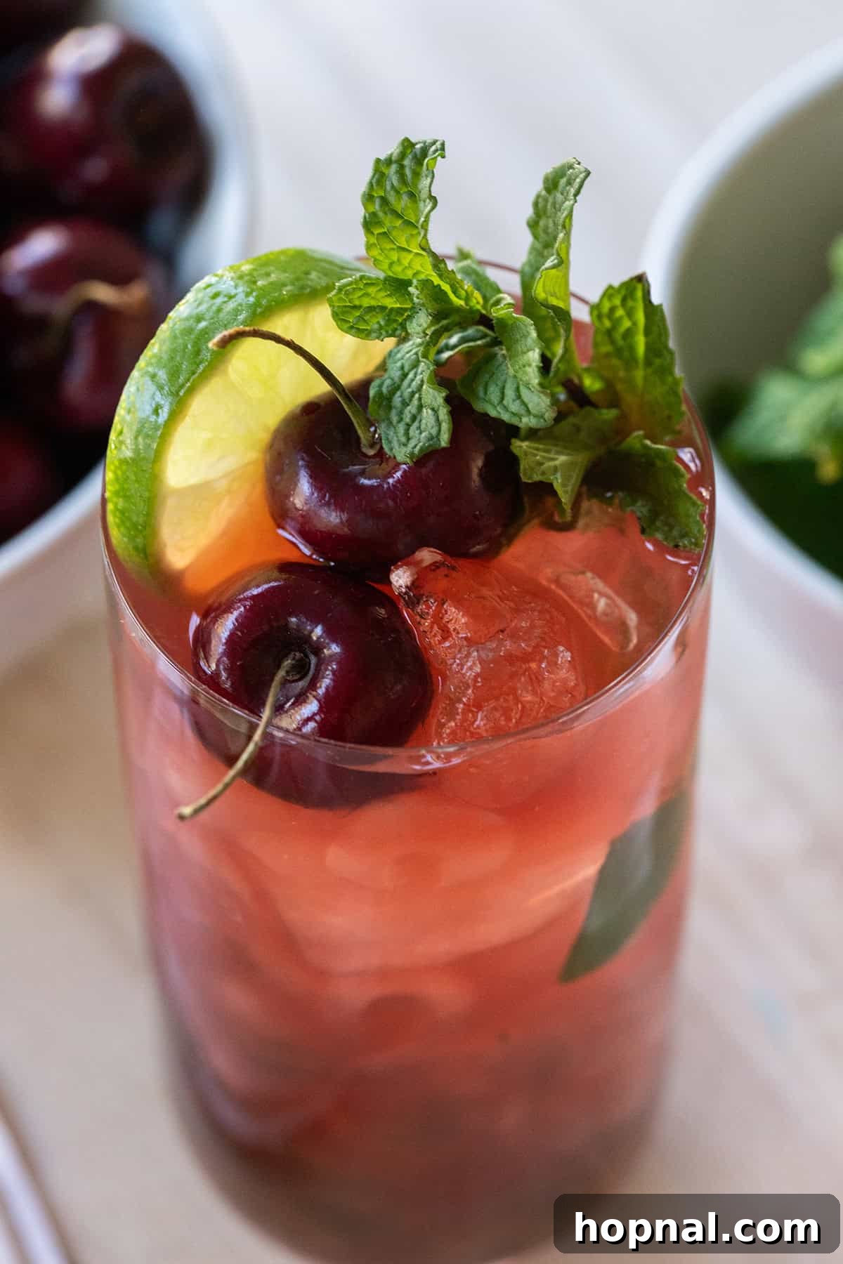 Cherry mojito recipe with fresh mint, cherries, and a lime wheel.