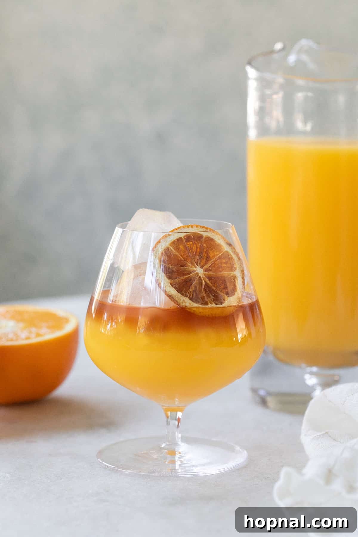 Coconut rum and orange juice drink with a flower garnish.