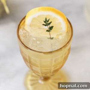 Lemonade in yellow glass with thyme sprig