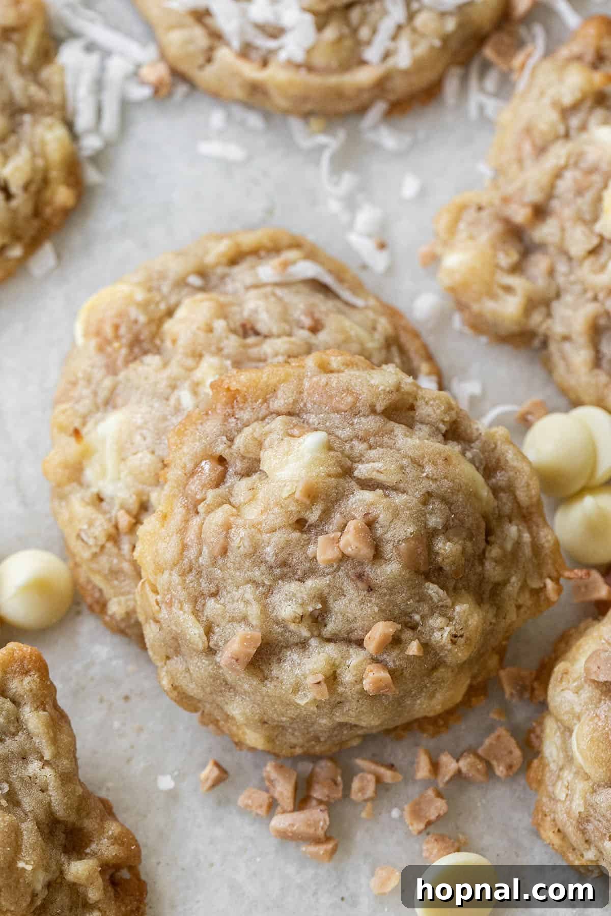 Ultimate Kitchen Sink Cookies 8 A selection of Kitchen Sink Cookies on a wire rack, showcasing their rich textures and variety of sweet and salty mix-ins like toffee, white chocolate, and shredded coconut.