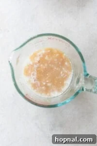 Buttermilk, apple cider, and vanilla extract combined in a liquid measuring cup.