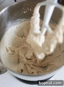 Creamed butter and sugars in a mixing bowl for apple cider donut batter.