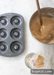 Donut batter, donut pan, and a piping bag ready for filling the pan.