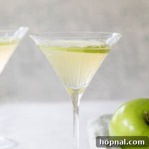 A delicious Apple Martini with a green apple garnish, ready to be enjoyed.