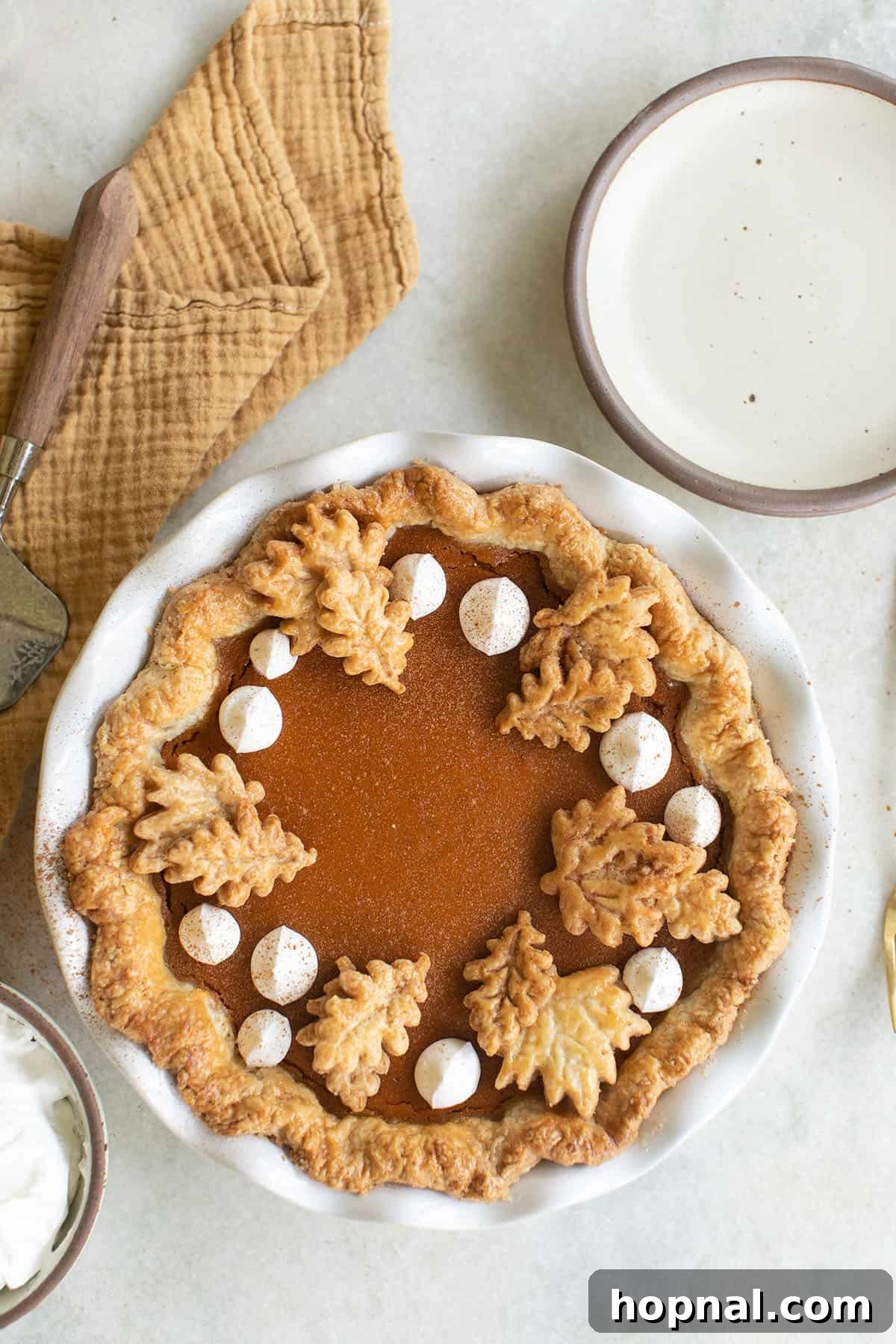 A beautiful sweet potato pie with whipped cream, and pie cut outs. 