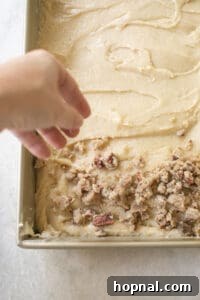 adding crumb cake topping over cake