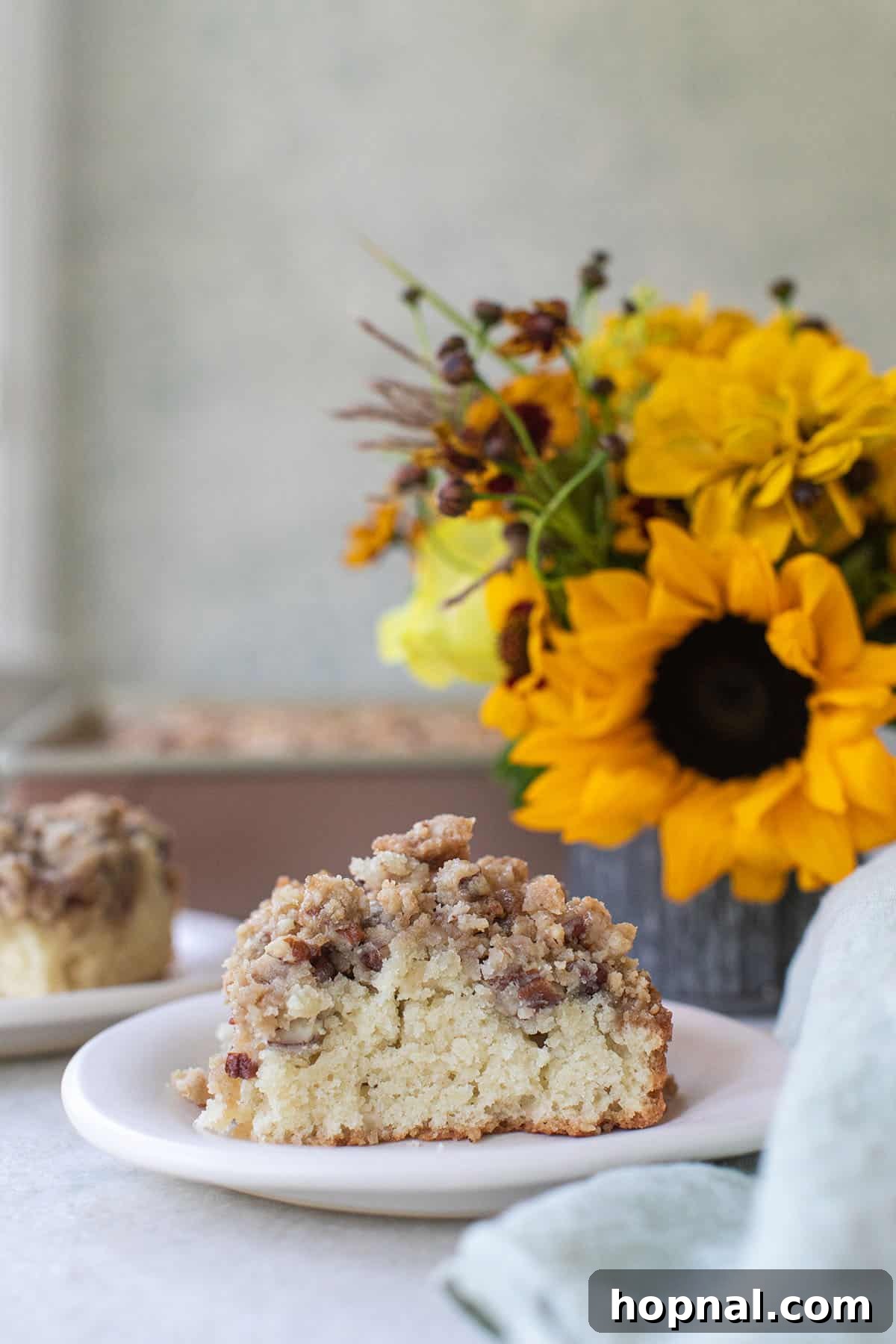 Authentic New York style Crumb Cake showcasing a rich, buttery pecan topping, ready to be served.