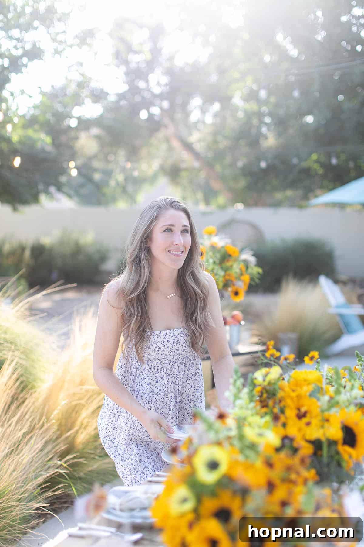 Eden Passante setting a fall harvest party table with sunflowers and autumn decorations