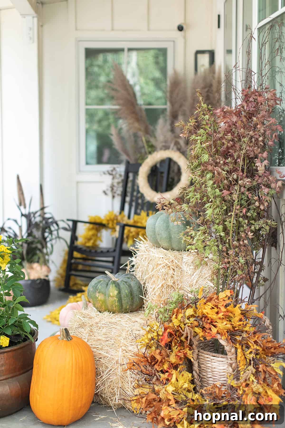 Fall porch ideas with pumpkins, wreaths and fall decor. A beautiful front porch adorned with an abundance of diverse pumpkins, lush fall wreaths, and vibrant autumnal decorations.