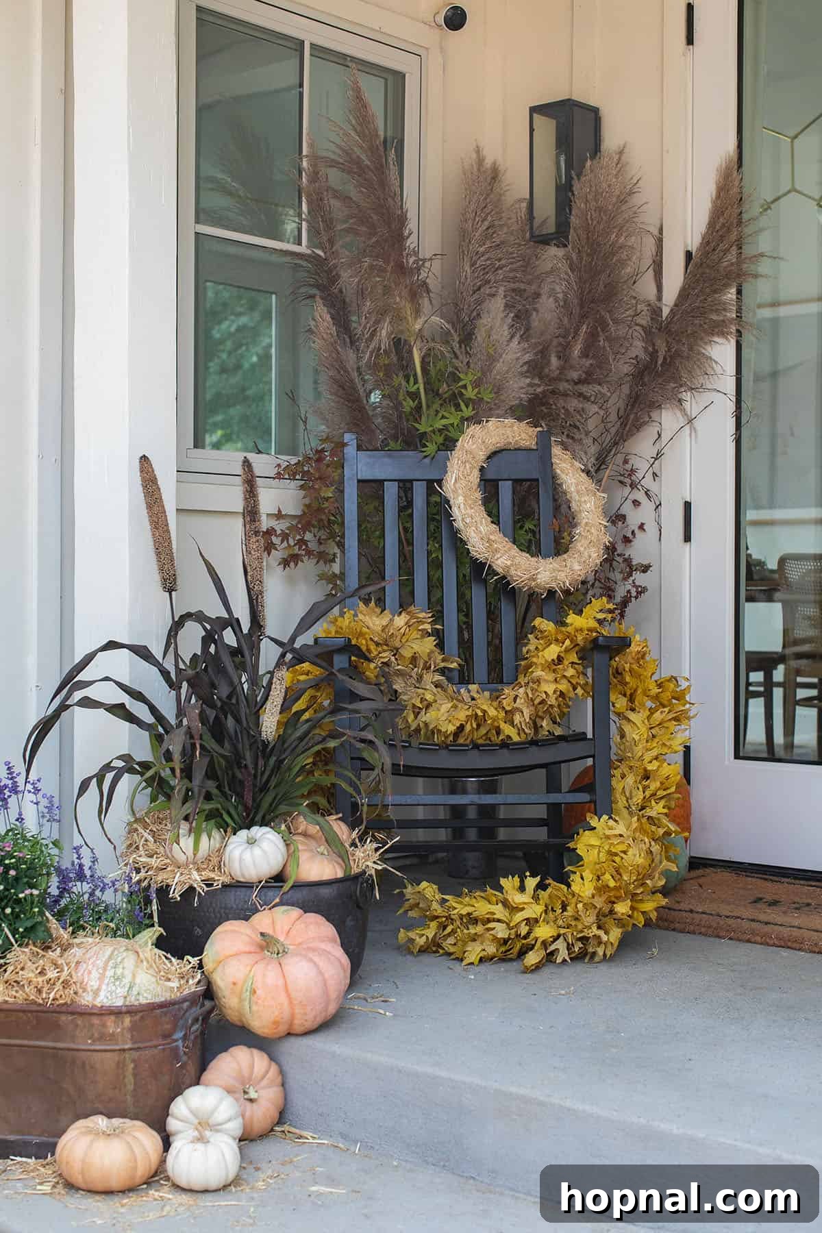 fall porch rocking chair and flowers. A cozy fall porch featuring a rocking chair adorned with a blanket, surrounded by vibrant fall flowers and pumpkins.