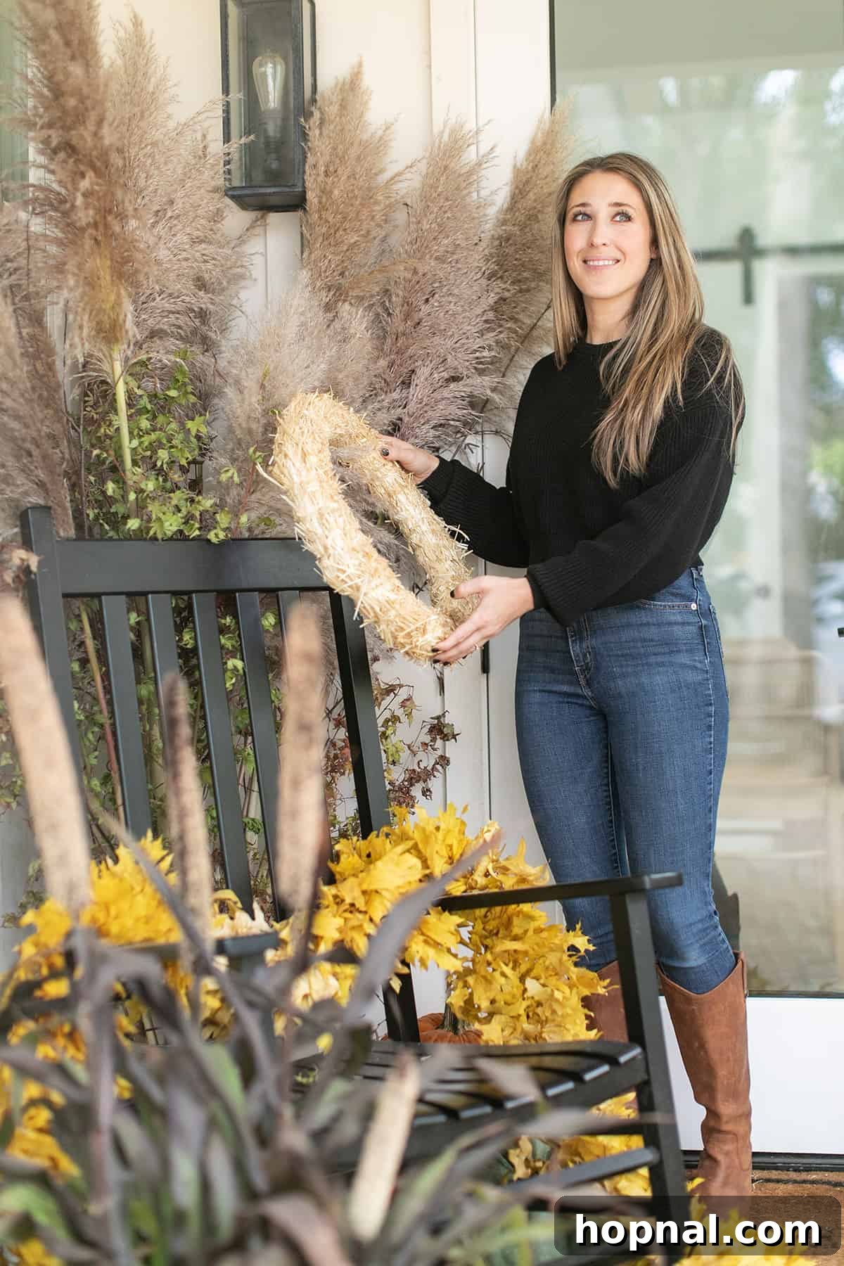 Entertaining expert Eden Passante decorating her fall porch. The entertaining expert, Eden Passante, meticulously decorating her front porch with various fall embellishments, ensuring a festive and welcoming ambiance.