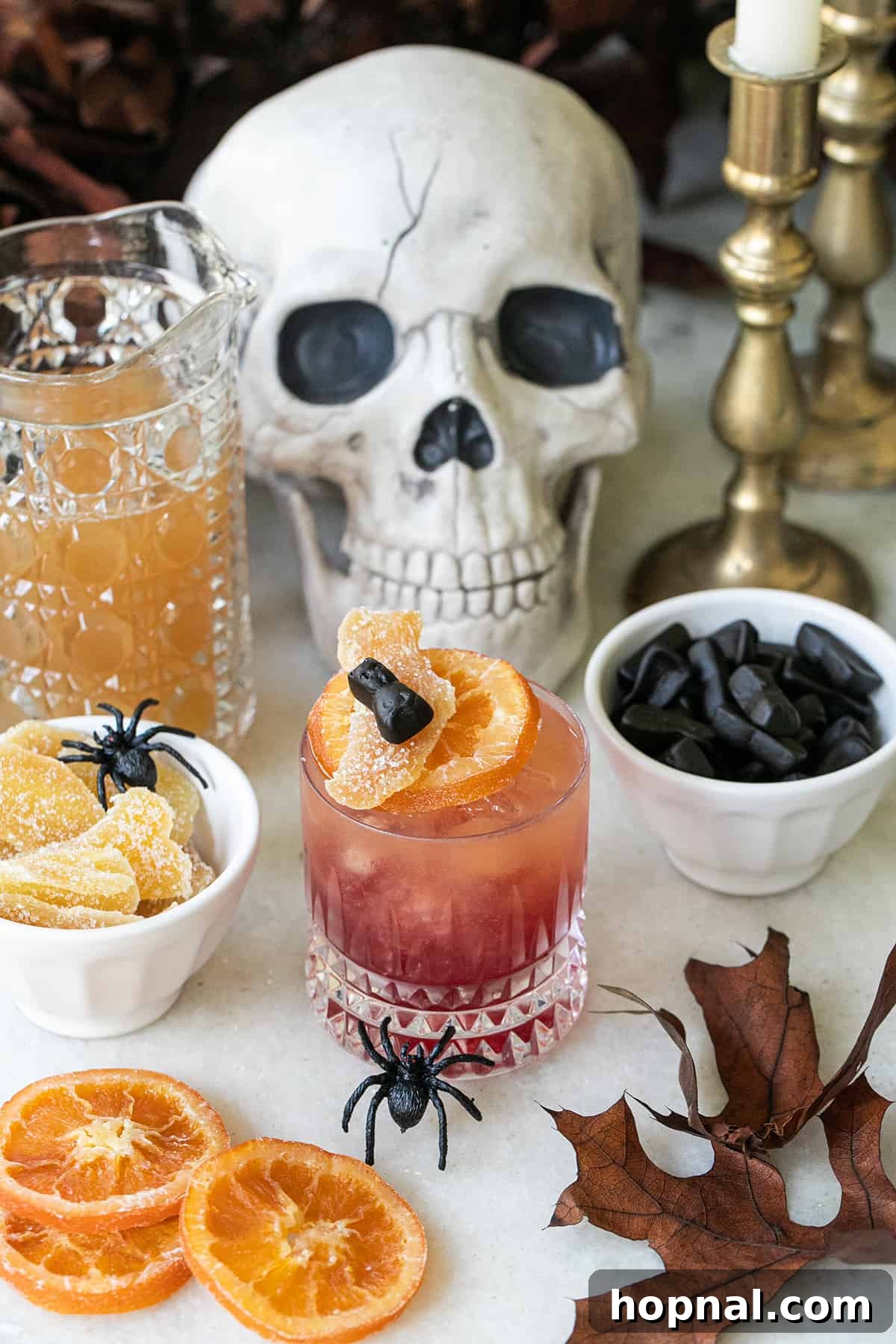 A beautifully garnished Witches Brew cocktail in an old-fashioned glass, ready for a Halloween party.