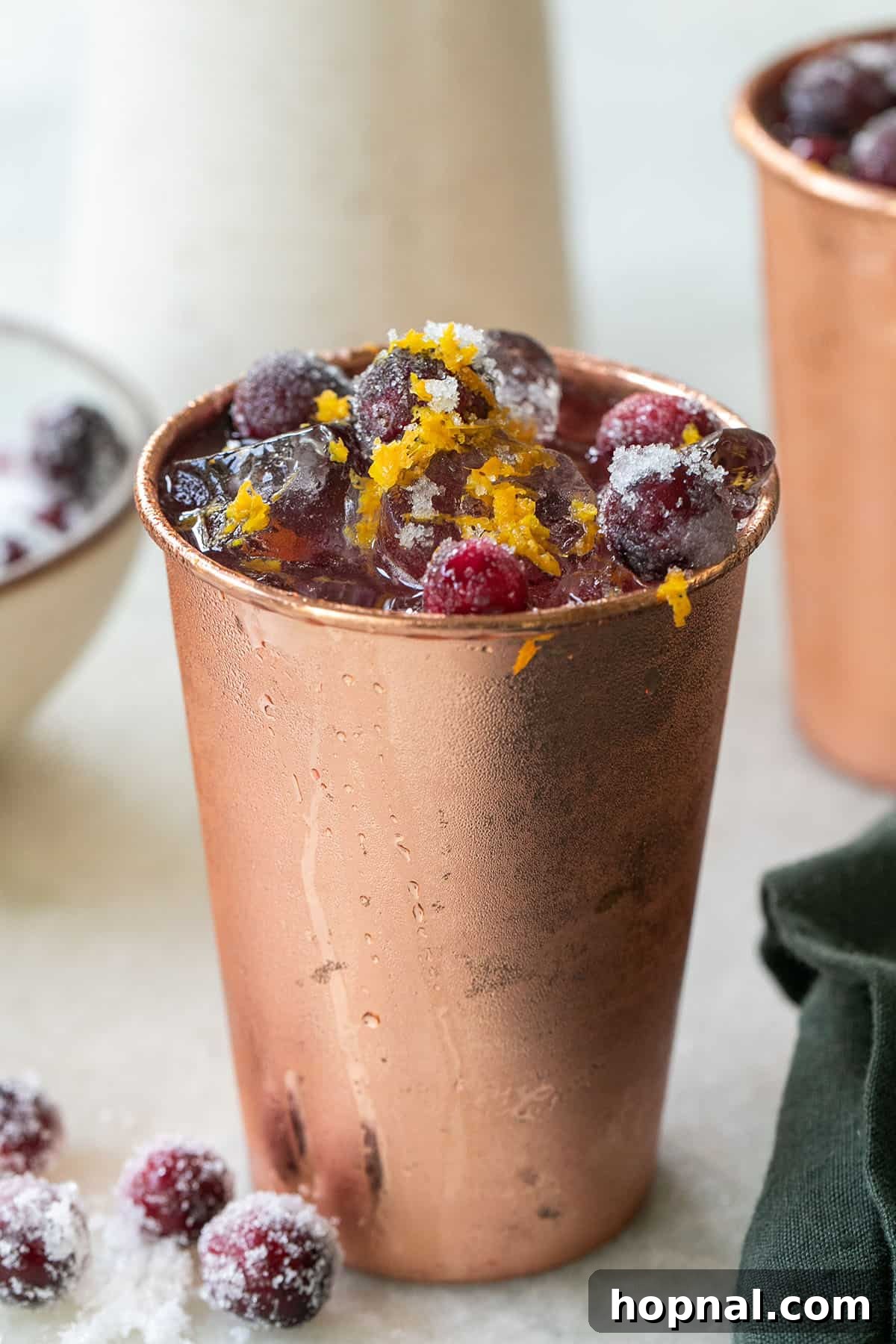 Spiced Cranberry Mule 5 Cranberry cocktail in a copper cup with sugared cranberries. - cranberry juice