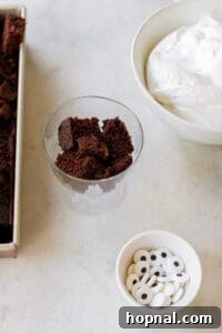 First layer of chocolate cake being placed in a mini trifle dish