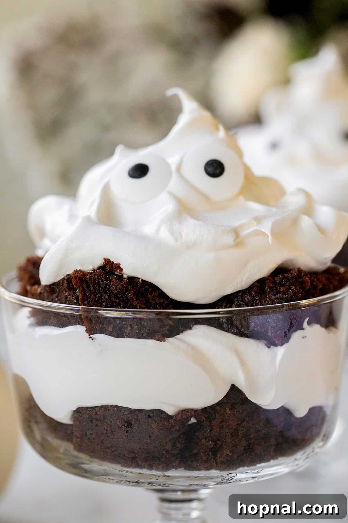 A beautifully finished mini ghost trifle featuring a fluffy whipped cream top and two playful candy eyes, ready to be served as a festive Halloween treat