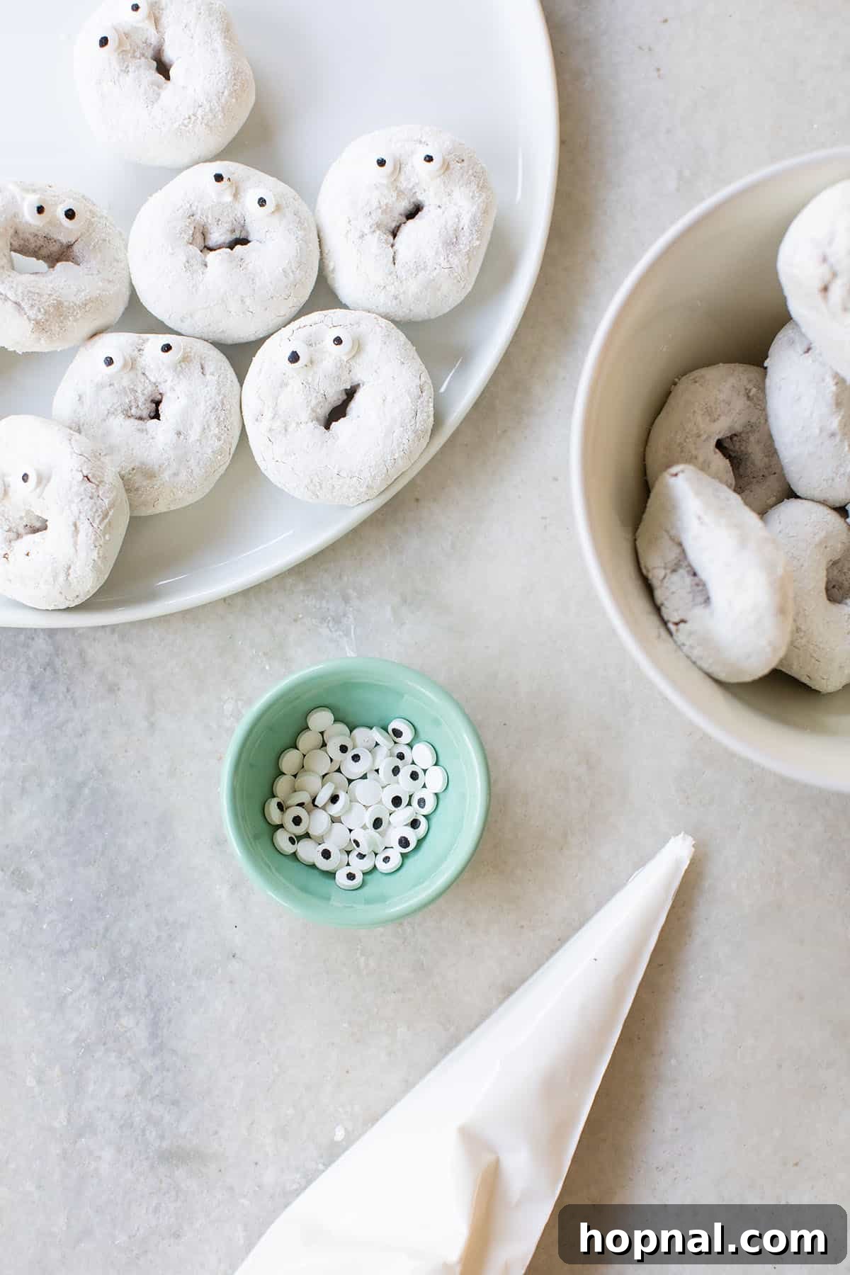 A collection of homemade ghost Halloween treats, including pretzels and donuts.