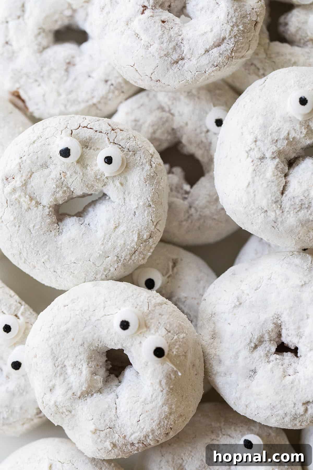 Close-up of mini ghost donuts with edible eyes, ready for a Halloween party.