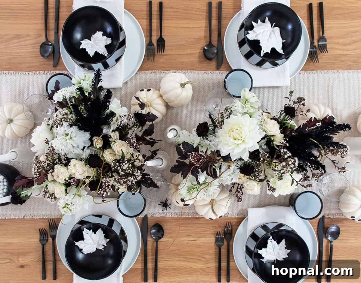 A ghost-themed Halloween table setting featuring white flowers and dark accents.
