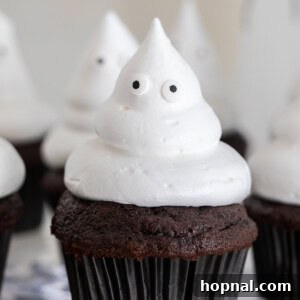 Close-up of a ghost cupcake with white frosting and edible eyes.